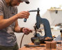 Derek adding brass rivets to a belt